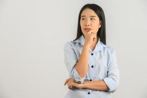 portret van jong Aziatisch vrouw in blauw overhemd denken en op zoek omhoog geïsoleerd Aan wit achtergrond foto