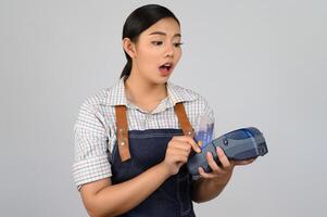 portret van jong Aziatisch vrouw in serveerster uniform houding met credit kaart foto