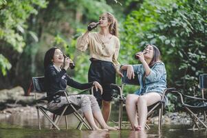 groep van Dames drinken bier en doorweekt voeten in stroom foto