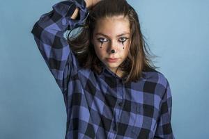 schattig, in de mode, brutaal Kaukasisch brunette met clown bedenken en lang haar, gekleed in een plaid overhemd foto