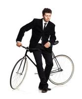 aantrekkelijk Mens in een klassiek pak met een fiets Aan een wit foto