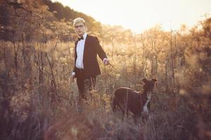 jong aantrekkelijk Mens in pak en stropdas met een windhond hond in herfst buitenshuis foto