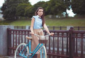 jonge mooie, elegant geklede vrouw met fiets foto