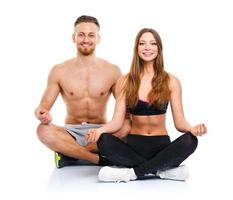 sport paar - Mens en vrouw na geschiktheid oefening zittend met halters Aan de wit foto