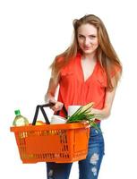 gelukkig vrouw Holding een mand vol van gezond voedsel. boodschappen doen foto