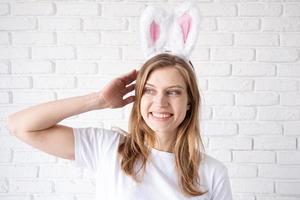 portret van een gelukkig vrouw in konijn oren Aan wit steen muur achtergrond foto