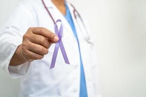 Aziatisch vrouw dokter met Purper lint, teken van alzheimer ziekte dag, alvleesklier kanker, epilepsie, lupus. foto