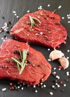 vers rauw rundvlees steak met kruid Aan zwart achtergrond foto