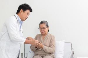 Aziatisch mannetje dokter uitleggen geneeskunde naar ouderen vrouw geduldig in ziekenhuis. foto