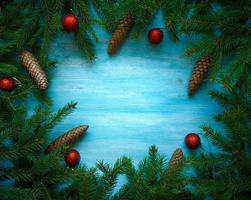 Kerstmis boom takken met kegels en Kerstmis decoraties Aan blauw houten structuur klaar voor uw ontwerp foto