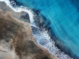 top visie van een uitgestorven strand. kust van de eiland van tenerife. antenne dar beeldmateriaal van zee golven bereiken kust foto