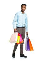Afrikaanse Amerikaans Mens Holding boodschappen doen Tassen Aan wit. vakantie concept foto
