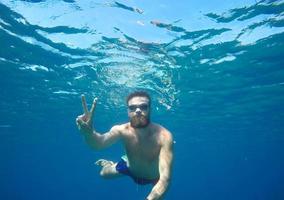 Mens aan het doen onderwater- selfie schot met selfie stok foto