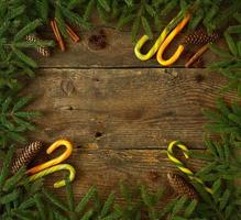Kerstmis boom Afdeling met kegels, kaneel, deuntje en snoep riet Aan houten achtergrond met copyspace foto