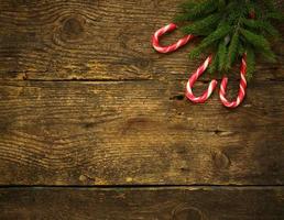 Kerstmis boom takken met snoep wandelstokken Aan houten structuur foto