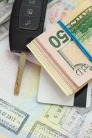 Amerikaans geld, credit kaarten en auto sleutel leugens Aan thr top van de geopend paspoort foto