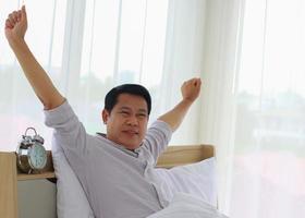 jonge Aziatische man wordt 's ochtends verfrist wakker foto
