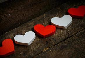 rood en wit harten Aan oud haveloos houten achtergrond foto