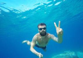Mens aan het doen onderwater- selfie schot met selfie stok in zee foto