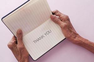 senior vrouwen hand- Holding dank u Notitie , top naar beneden foto