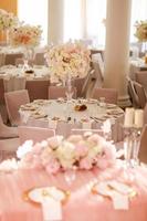 feestelijk bruiloft decoratie. mooi vers wit en roze bloemen in glas vaas Aan dining tafel Aan bruiloft dag. hoog kwaliteit foto