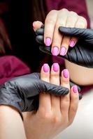 manicure houdt roze vrouw vingernagels foto