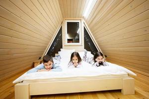 kinderen in zacht warm pyjama spelen Bij houten cabine huis. concept van jeugd, vrije tijd werkzaamheid, geluk. broer en zussen hebben pret en spelen samen. foto