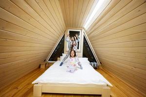 kinderen in zacht warm pyjama spelen Bij houten cabine huis. concept van jeugd, vrije tijd werkzaamheid, geluk. broer en zussen hebben pret en spelen samen. foto