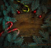 Kerstmis grens met Spar boom takken, kegels, Kerstmis decoraties en snoep riet foto