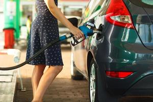 vrouw vult benzine in haar auto foto