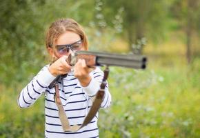 een jong meisje met een geweer voor val het schieten foto
