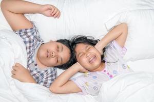 zus sluitend oren met handen lijden van luid snurken van haar broer. foto
