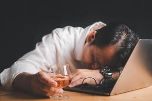 zakenman houden whisky glas en slaap Aan laptop, foto