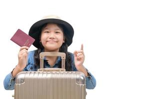 schattig Aziatisch kind klaar naar reizen vervelend een hoed en Holding haar paspoort met bagage geïsoleerd foto