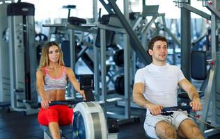 Mens en vrouw werken uit Bij de Sportschool foto