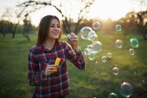 vrouw blazen bubbels buitenshuis foto