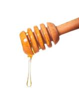 honing die uit een houten lepel druipt foto