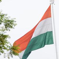 indiase vlag hoog op connaught plaats met trots in blauwe lucht, indiase vlag wapperen, indiase vlag op onafhankelijkheidsdag en republiek dag van india, tilt-up shot, wuivende indische vlag, har ghar tiranga foto