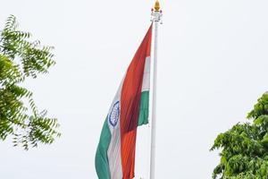 indiase vlag hoog op connaught plaats met trots in blauwe lucht, indiase vlag wapperen, indiase vlag op onafhankelijkheidsdag en republiek dag van india, tilt-up shot, wuivende indische vlag, har ghar tiranga foto