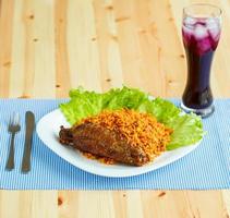 gerechten van kalkoen vlees met rijst- en salade bladeren en een glas van sap met ijs foto