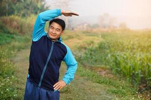 knap Aziatisch Mens trainingen buitenshuis, lichaam uitrekken. warm omhoog voordat of koel naar beneden na oefening. concept, Gezondheid zorg. sport.creatief werkzaamheid. geven tijd voor jezelf. foto