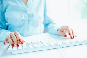 vrouw kantoor arbeider typen Aan de toetsenbord foto