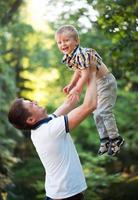 vader en zijn baby zoon hebben pret in de park buitenshuis foto