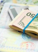 Amerikaans geld en credit kaarten liggen Aan de top van de geopend paspoort foto