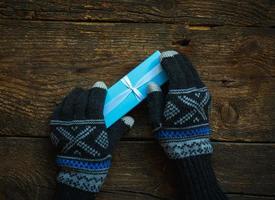 handen in winter handschoenen met kerst geschenkdoos foto