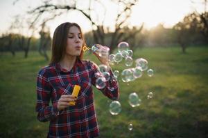 vrouw blazen bubbels buitenshuis foto