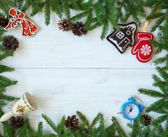 Kerstmis grens met Spar boom takken, Kerstmis decoraties en snoep riet Aan wit houten borden foto