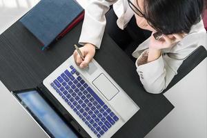 jonge vrouw die op laptop werkt foto