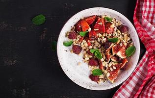 chia zaad pudding gemaakt met frambozen, vijgen en munt Aan donker achtergrond. de concept van mooi zo voeding. top visie foto