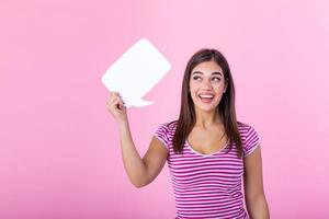 vrouw tonen teken toespraak bubbel banier op zoek gelukkig opgewonden Aan roze achtergrond. mooi jong blij model- Aan roze achtergrond hebben idee. foto